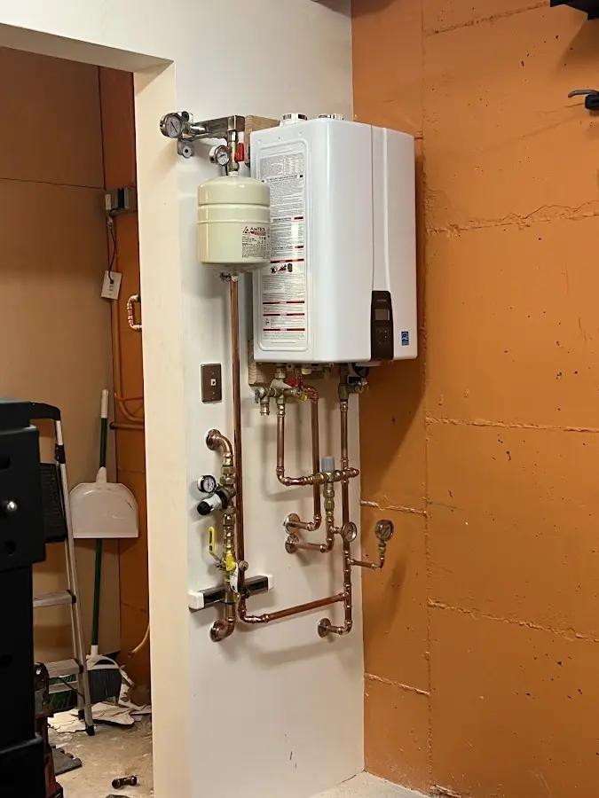 Plumbing technician inspecting water heater connections in Bryn Mawr-Skyway